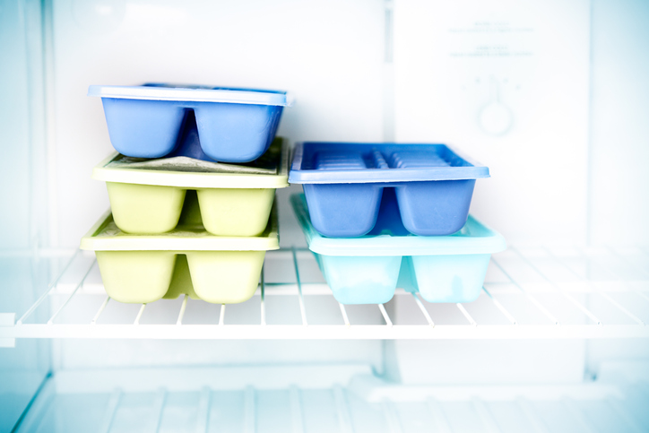 Stacked ice cube trays in a freezer