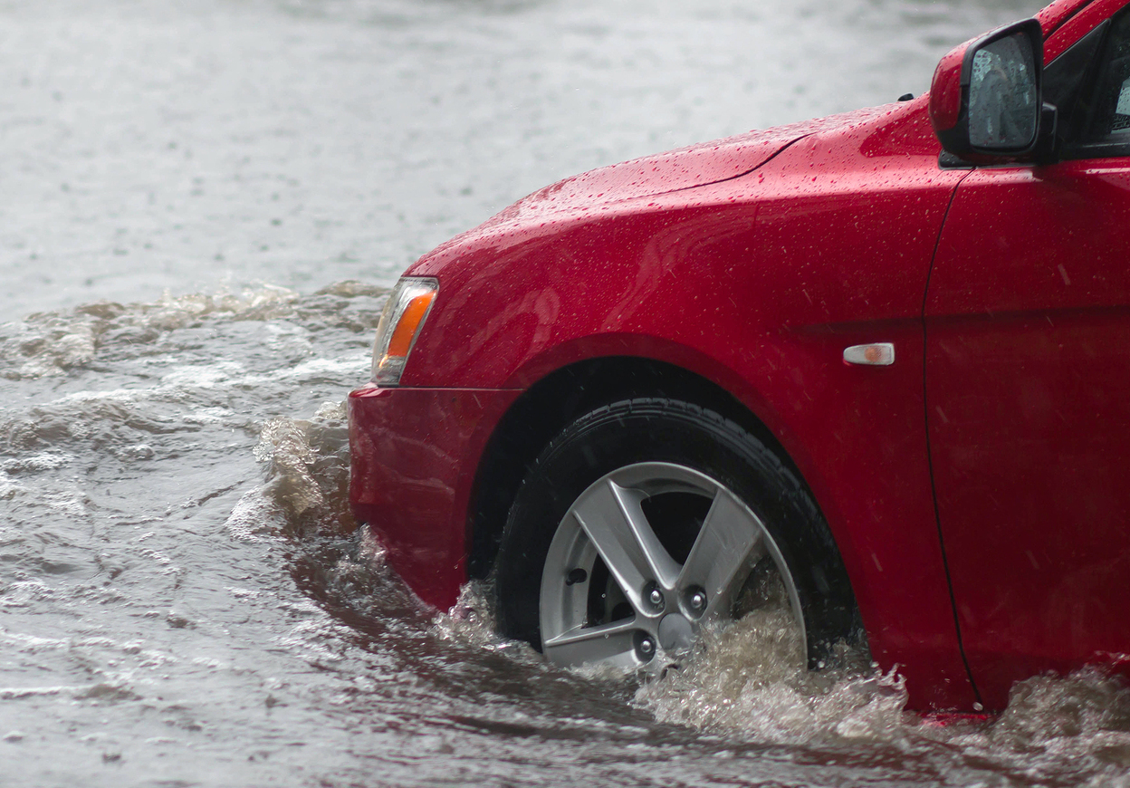 car rides in heavy rain on a flooded road